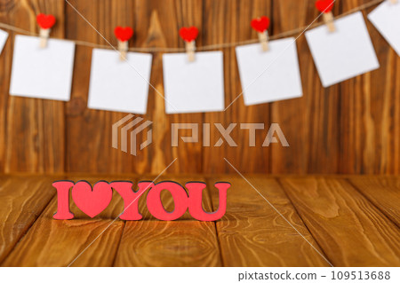 white pieces of paper on clothespins with a heart on a wooden background, a wooden inscription I love you white pieces of paper on clothespins with a heart on a wooden background, a wooden inscription I love you 109513688