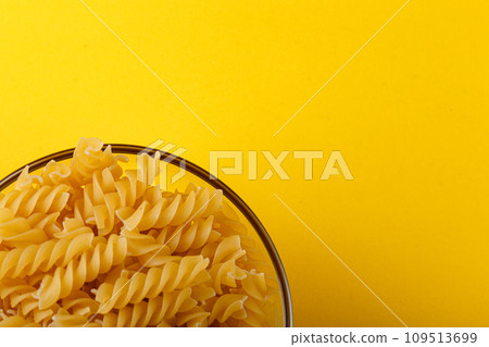 Different types and shapes of dry italian pasta on a yellow background 109513699