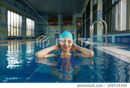 Young sportive woman wearing swimsuit and goggles in pool portrait Young sportive woman wearing swimsuit and goggles in pool portrait 109514344