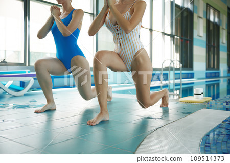 Two athletic sportive woman doing training workout before swimming Two athletic sportive woman doing training workout before swimming 109514373