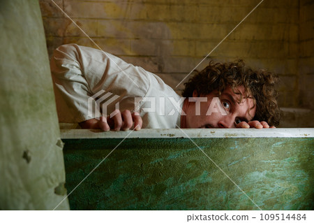 Crazy man hiding in bathtub feeling scared suffering from schizophrenia 109514484