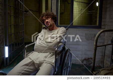 Mentally ill patient wearing straitjacket sitting in wheelchair Mentally ill patient wearing straitjacket sitting in wheelchair 109514493