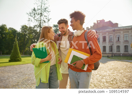 Multinational group of cheerful students hugging together chatting and laughing Multinational group of cheerful students hugging together chatting and laughing 109514597