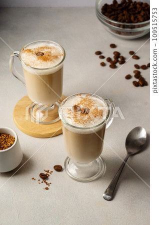 Two glass cups with coffee drink, latte with milk foam and cinnamon Two glass cups with coffee drink, latte with milk foam and cinnamon 109515753