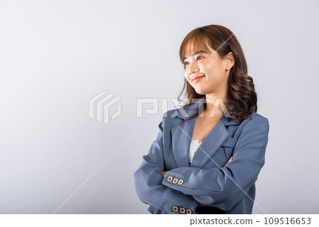 Confident Asian woman with a radiant smile, standing with crossed arms in a studio shot on a white background. Copy space available for your message. Confident Asian woman with a radiant smile, standing with crossed arms in a studio shot on a white background. Copy space available for your message. 109516653
