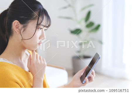 Thinking young woman smartphone 109516751