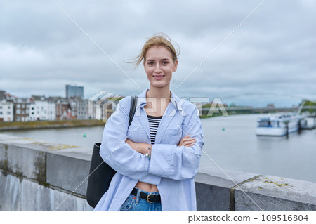 Portrait of smiling young teenage girl looking at camera outdoor 109516804