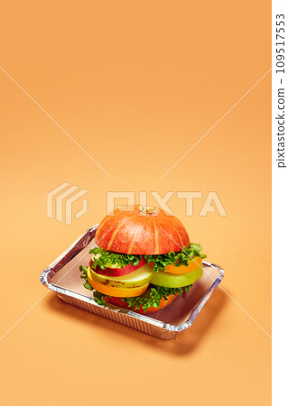 Healthy burger made with fresh vegetables and fruits against orange background. Organic products and healthy food Healthy burger made with fresh vegetables and fruits against orange background. Organic products and healthy food 109517553