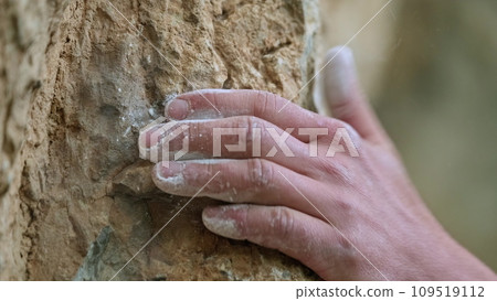 The Connection Between Human and Nature: A Person's Hand Resting on the Texture of a rock 109519112
