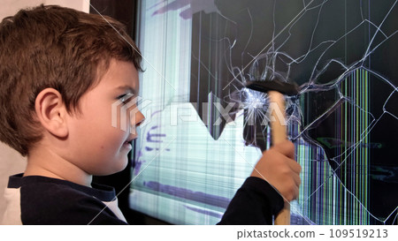 The Handyman in Training: A Young Boy with a Hammer Fixes a Broken Screen TV 109519213