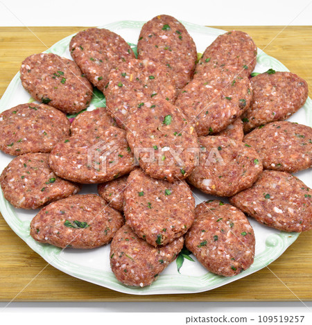 Raw beef meatballs made with various homemade spices, raw beef kofte kofta, on bamboo cutting board Raw beef meatballs made with various homemade spices, raw beef kofte kofta, on bamboo cutting board 109519257