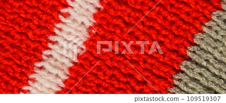 Handmade knitted fabric red white and grey wool background texture Handmade knitted fabric red white and grey wool background texture 109519307