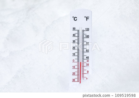 Thermometer on snow shows low temperatures - zero. Low temperatures in  degrees Celsius and fahrenheit. Cold winter weather - zero celsius thirty  two farenheit