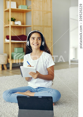Pre-teen girl using tablet studying online Pre-teen girl using tablet studying online 109520229