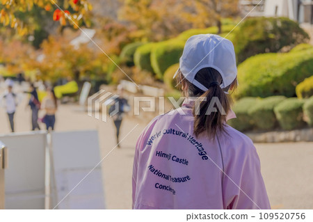 Himeji, Hyogo Prefecture of Japan. Nov 10, 2023. A staff member of the Himeji Castle welcoming visitors. At a Japanese castle complex, an UNESCO World Heritage Site. 109520756