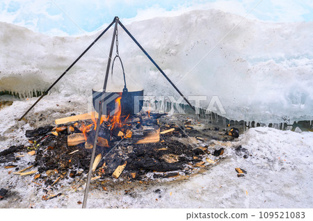 A fire pot using for cooking fish soup during camping on lake Baikal, Russia. Local fisherman cooked on fire, with the help of hot stones and coals. 109521083