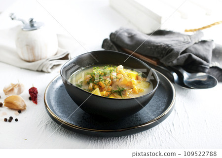 Pea soup with pieces of bacon and parsley in a bowl on a table Pea soup with pieces of bacon and parsley in a bowl on a table 109522788