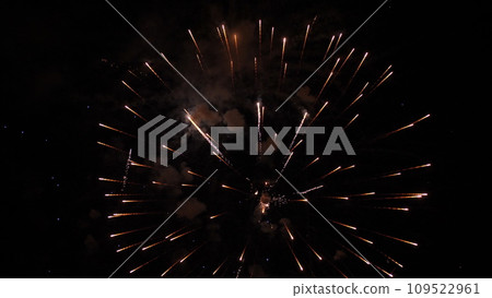 Fireworks draw amazing pattern of sparkling blasts in black night sky. Fireworks dazzling display entertains spectators at night festival. Fireworks performance in dark night at holiday party Fireworks draw amazing pattern of sparkling blasts in black night sky. Fireworks dazzling display entertains spectators at night festival. Fireworks performance in dark night at holiday party 109522961