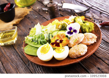 Fried salmon cutlets on a plate with vegetables and boiled eggs Fried salmon cutlets on a plate with vegetables and boiled eggs 109523008