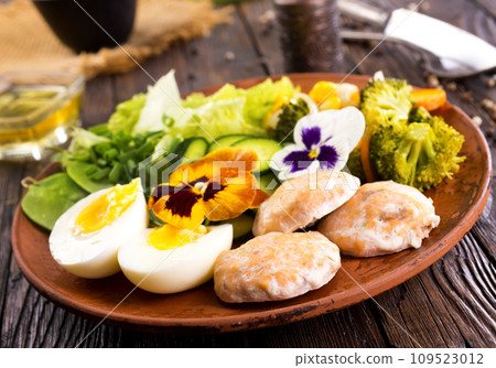 Fried salmon cutlets on a plate with vegetables and boiled eggs Fried salmon cutlets on a plate with vegetables and boiled eggs 109523012