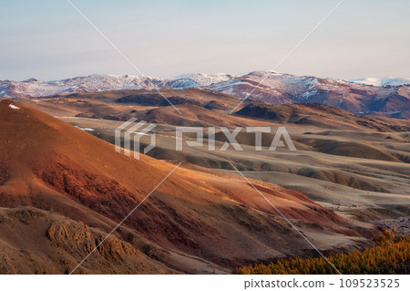 Unusual texture of the mountains, there is snow in the veins of the rock, the surface of the plateau is heated by the sun. Amazing red mountain plateau at sunset is lightly sprinkled with snow. Unusual texture of the mountains, there is snow in the veins of the rock, the surface of the plateau is heated by the sun. Amazing red mountain plateau at sunset is lightly sprinkled with snow. 109523525