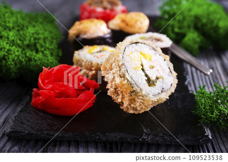 Sushi roll with salmon, smoked eel, avocado, cream cheese on black background. Sushi menu. Japanese food. 109523538