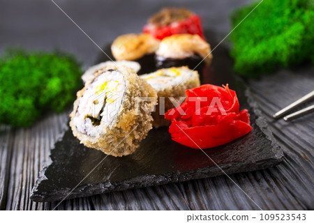 Sushi roll with salmon, smoked eel, avocado, cream cheese on black background. Sushi menu. Japanese food. 109523543