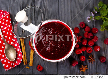 Raspberry jam with berry on dark background. Raspberry jam with berry on dark background. 109523548