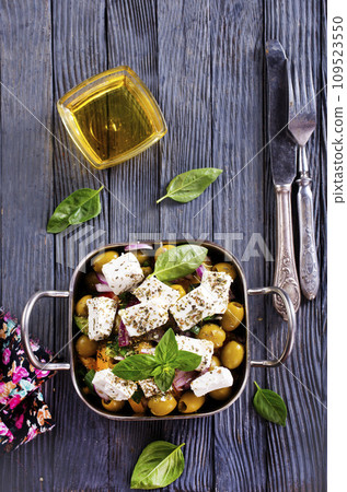 feta cheese with olives and olive oil sauce in bowl on dark background. 109523550