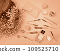 Cosmetics and cosmetic brushes are laid out on the table.  109523710