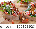 Delicious canapes with rucola-tomato-salad and fried chanterelles 109523923