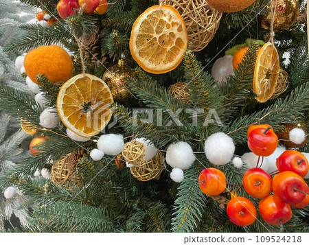 Zero waste christmas concept. Christmas tree decorated with ornaments made of natural materials - slices of dried orange and cones Zero waste christmas concept. Christmas tree decorated with ornaments made of natural materials - slices of dried orange and cones 109524218