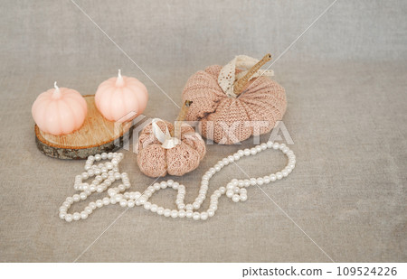 Hobby background with handmade knit pumpkins and white pearl beads. DIY, craft decoration for fall and winter holidays. 109524226