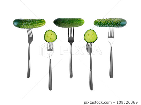 Cucumber slices on forks isolated on white background Cucumber slices on forks isolated on white background 109526369