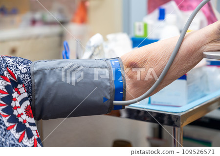 Female nurse checking blood pressure of a senior woman Female nurse checking blood pressure of a senior woman 109526571