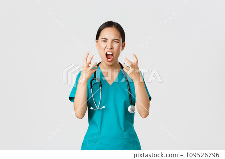 Covid-19, healthcare workers and preventing virus concept. Angry pissed-off asian female nurse, doctor losing temper, stressed-out physician shouting in anger, looking mad and aggressive 109526796