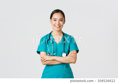 Covid-19, healthcare workers, pandemic concept. Portrait of confident smiling, attractive asian female nurse in scrubs, with stethoscope, cross arms chest and looking at camera, white background Covid-19, healthcare workers, pandemic concept. Portrait of confident smiling, attractive asian female nurse in scrubs, with stethoscope, cross arms chest and looking at camera, white background 109526812