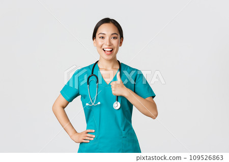 Covid-19, healthcare workers, pandemic concept. Smiling upbeat, confident female asian nurse in scrubs have all under control, show thumbs-up in approval, guarantee quality of service in clinic Covid-19, healthcare workers, pandemic concept. Smiling upbeat, confident female asian nurse in scrubs have all under control, show thumbs-up in approval, guarantee quality of service in clinic 109526863