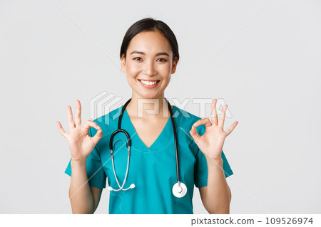Healthcare workers, preventing virus, quarantine campaign concept. Satisfied good-looking asian female nurse, doctor showing okay gesture in approval, recommend or guarantee perfect service Healthcare workers, preventing virus, quarantine campaign concept. Satisfied good-looking asian female nurse, doctor showing okay gesture in approval, recommend or guarantee perfect service 109526974