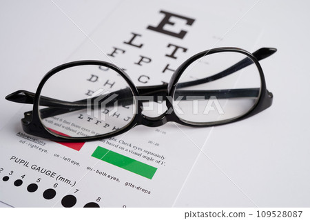Glasses on eye exam chart to test eyesight accuracy of reading. Glasses on eye exam chart to test eyesight accuracy of reading. 109528087
