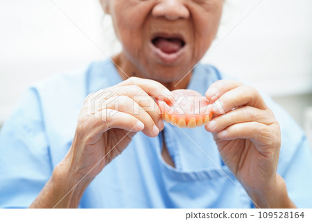 Doctor holding teeth denture in hand for dentist studying about dentistry. 109528164