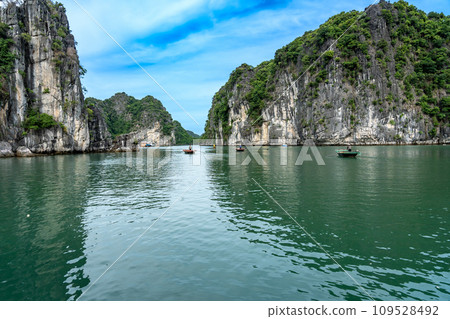 越南：一名船夫在下龍灣劃著一艘划艇，周圍都是奇形怪狀的岩石。 109528492