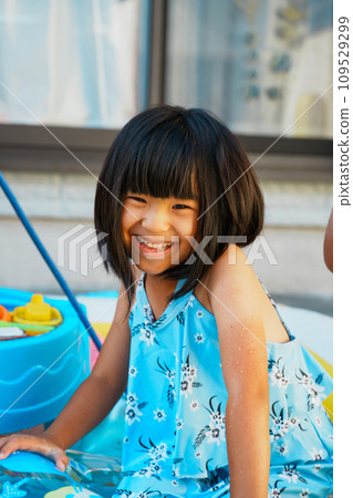 A girl playing in the water with a smile A girl playing in the water with a smile 109529299