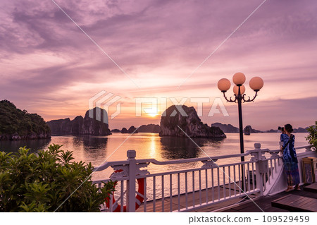 一名女子在越南下龍灣的遊輪甲板上拍攝日落照片 109529459
