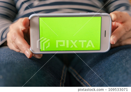 Close-up of female hands showing white mobile phone with blank screen 109533071