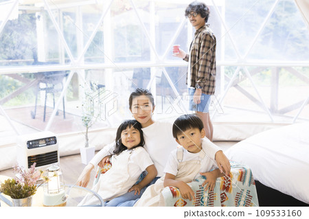 Parents and children relaxing at a glamping facility Parents and children relaxing at a glamping facility 109533160