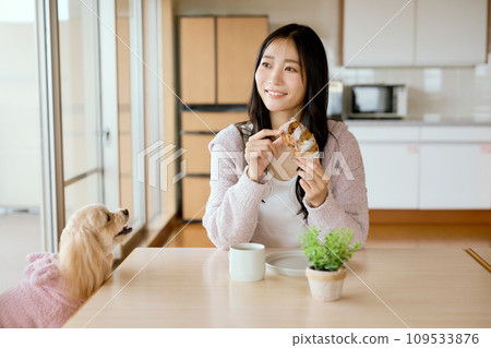 Eating breakfast with pet dog at dining table 109533876