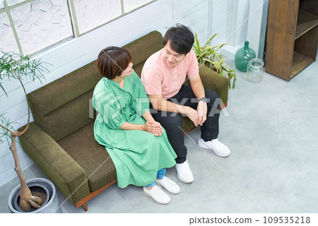 Young man and woman sitting on the sofa and talking 109535218
