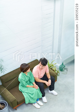 Young man and woman sitting on the sofa and talking Young man and woman sitting on the sofa and talking 109535219