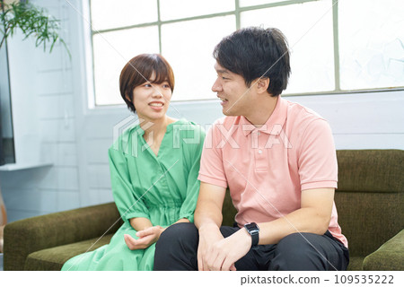 年輕男女坐在沙發上聊天 年輕男女坐在沙發上聊天 109535222